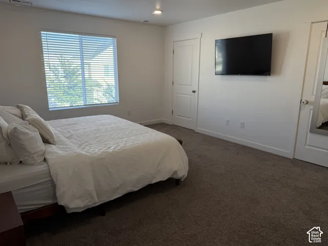 Plush carpeting, recessed lighting, and a window with horizontal blinds