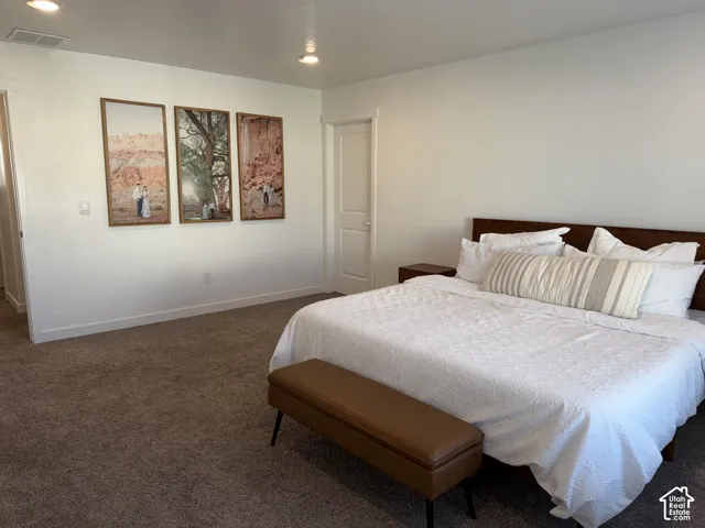 Recessed lighting, wood-finish headboard, built-in shelving, carpeted flooring, and white interior doors