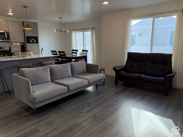 Open-concept living area featuring wood-finish flooring, recessed lighting, and a kitchen island with seating