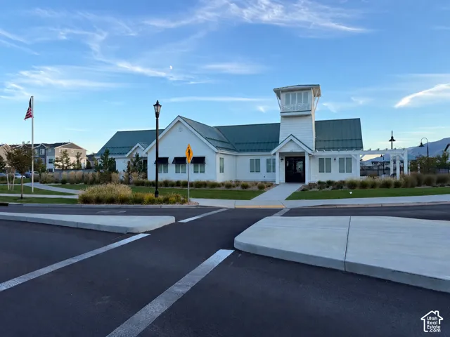 Single-story building with white siding, dark green roof, and a prominent cupola