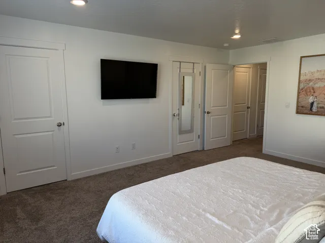 White walls with recessed lighting and neutral-toned carpeting