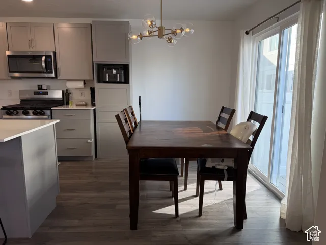 Kitchen with gray cabinetry, stainless steel appliances, wood-finish flooring, and a sliding glass door