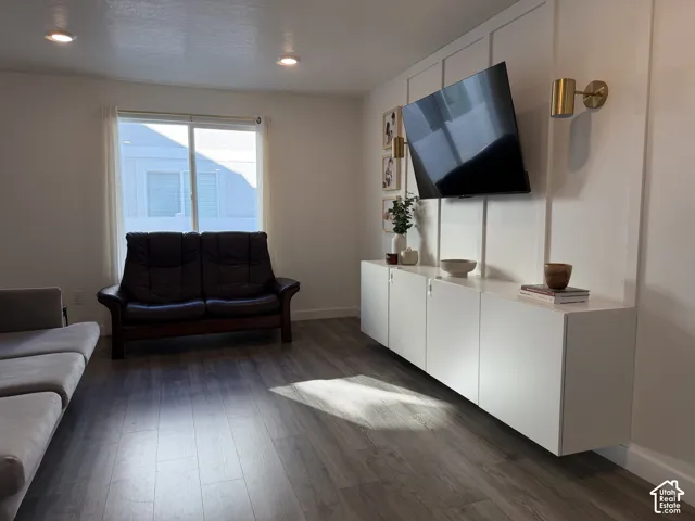 Wood-finish flooring, recessed ceiling lighting, wall-mounted storage cabinetry, and a large window