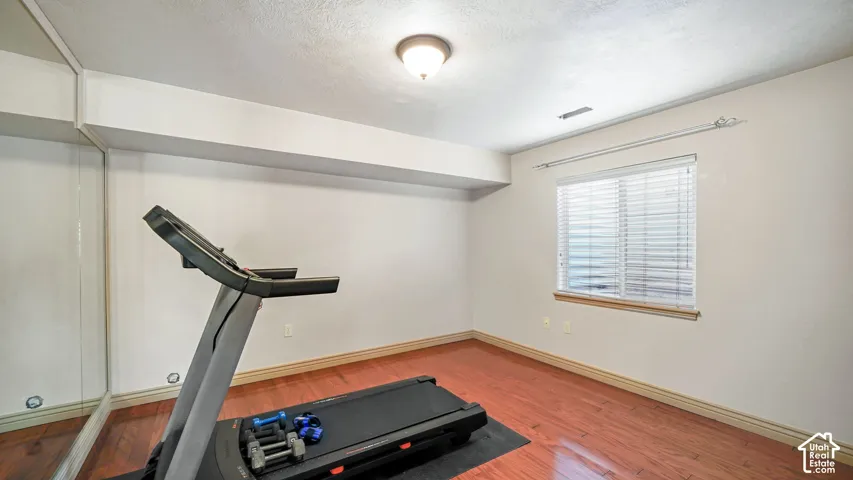 Hardwood-finish flooring, full-wall mirror, window with blinds