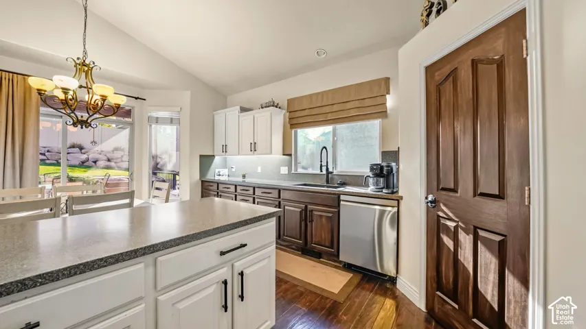 Kitchen featuring a central island with a solid surface countertop, two-tone cabinetry, hardwood  flooring, and stainless steel energy efficient appliances