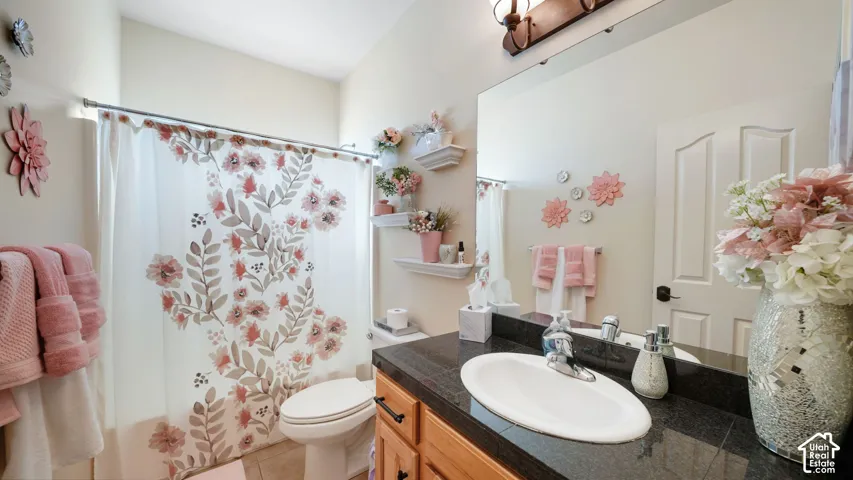 Vanity with a built-in sink, dark stone countertop, and large wall-mounted mirror