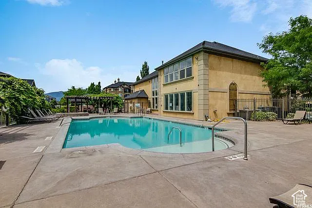 Expansive outdoor swimming pool with integrated spa and concrete surround