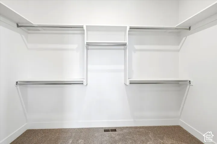 Built-in closet organization system featuring white shelving and chrome hanging rods