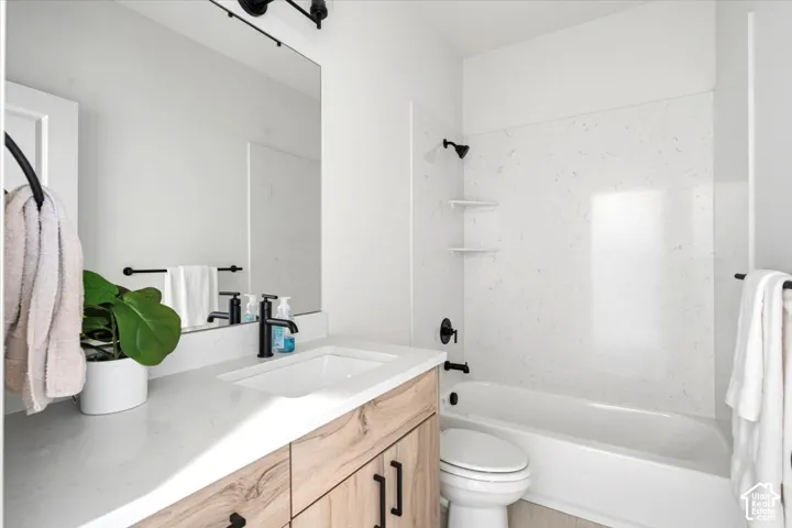 White bathtub with dark-toned fixtures and built-in shelving