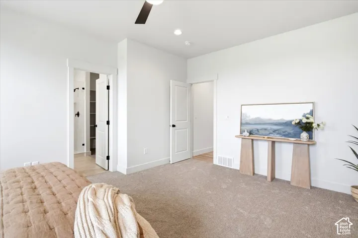 Neutral wall colors, recessed lighting, ceiling fan, and carpeted flooring