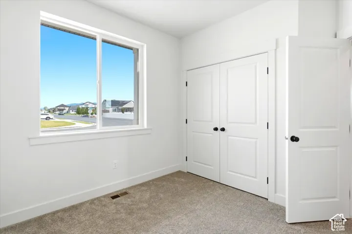 White walls, neutral carpeting, and a double-panel interior door