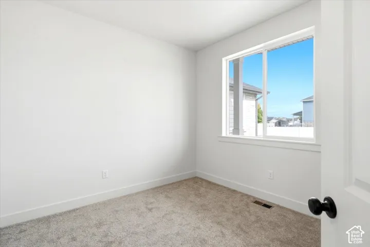 White painted walls, white trim, and gray carpeted flooring