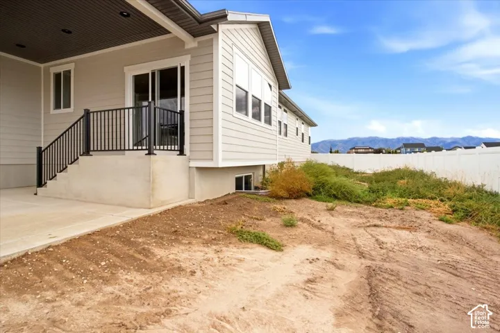 Exterior patio with concrete steps, black metal railing, and sliding glass door access