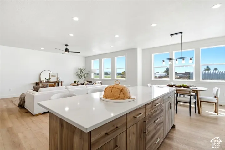 Kitchen island with a light-toned countertop, wood-finish cabinetry, and contemporary hardware