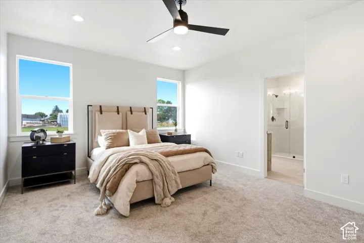 Recessed lighting, ceiling fan, plush carpet flooring, and an en-suite bathroom with a glass-enclosed shower