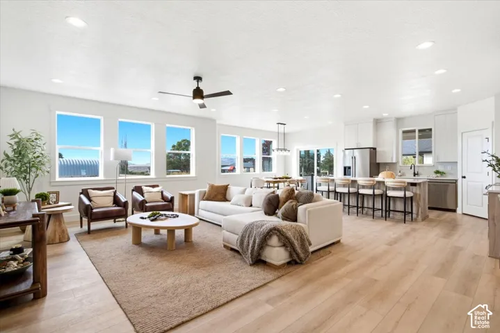 Open-concept living space featuring wood-finish flooring, recessed lighting, and a ceiling fan