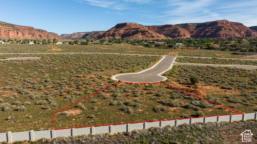 Expansive lot featuring a perimeter wall, paved road access, and distinct desert landscaping
