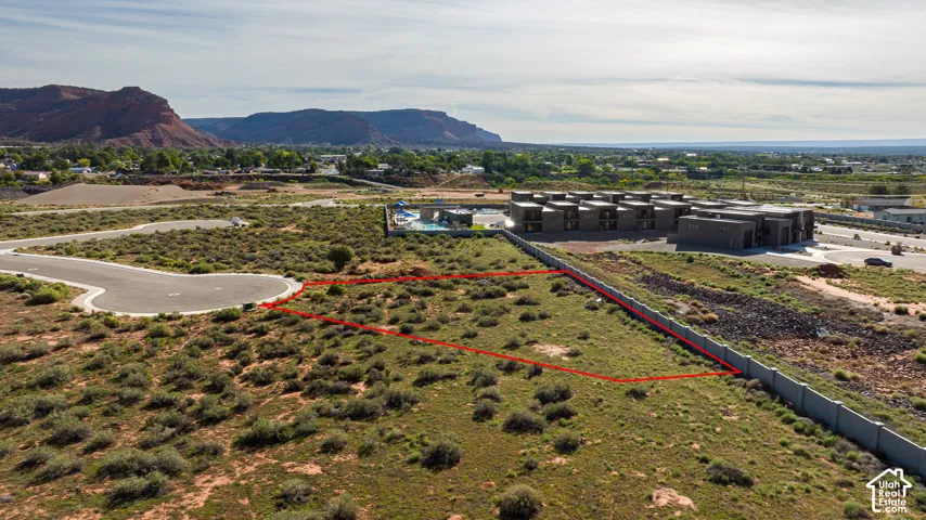 Expansive lot featuring natural desert vegetation, a curbed paved cul-de-sac, and distant mountain backdrops