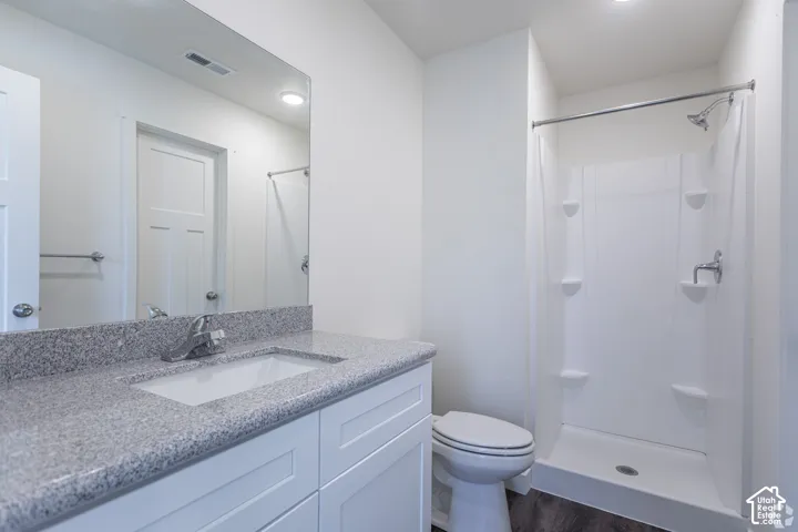 White vanity with a light-toned stone countertop and undermount sink