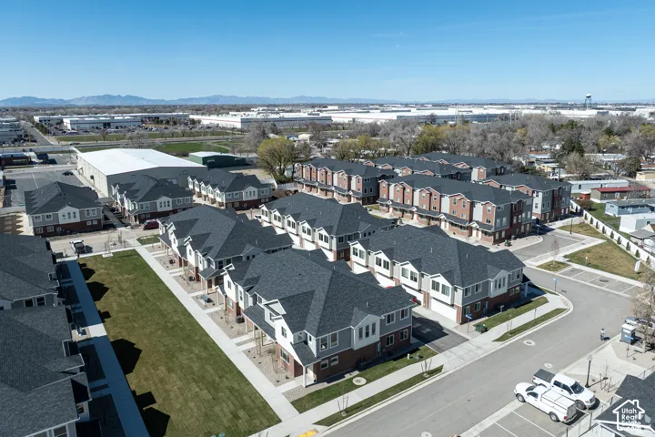 Modern townhome community featuring multi-story units with attached garages, individual balconies, and a central green space