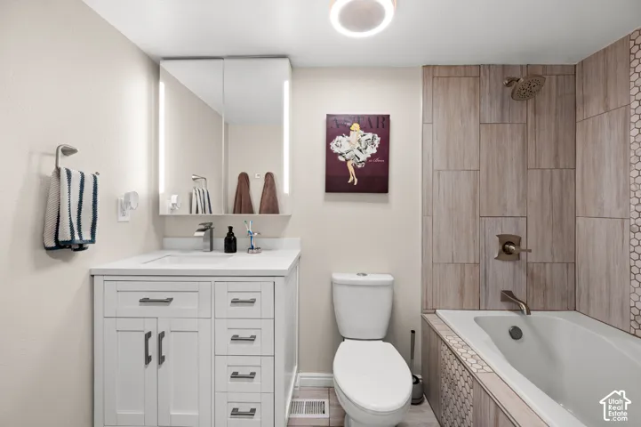 White vanity with a quartz countertop, an integrated sink, and brushed nickel hardware