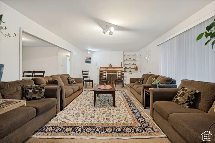 Spacious living area with an architectural opening, recessed lighting, and a decorative fireplace