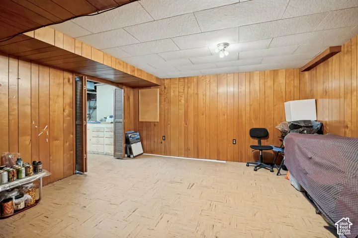 Wood-paneled walls with a drop ceiling and recessed lighting