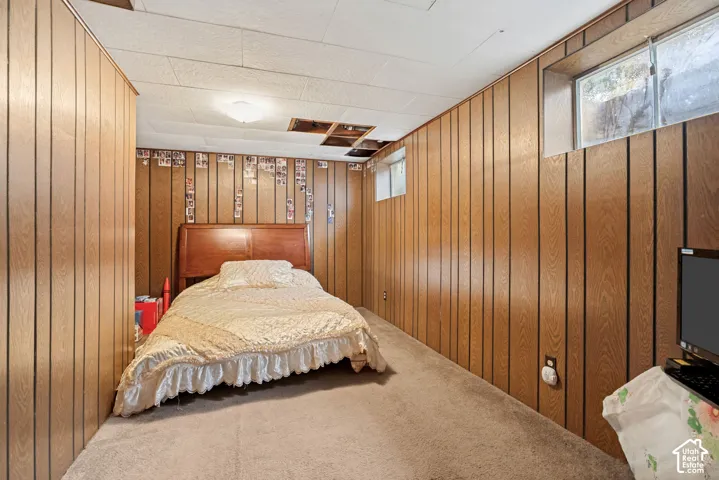Wood-paneled walls with light-toned carpeting and a suspended ceiling