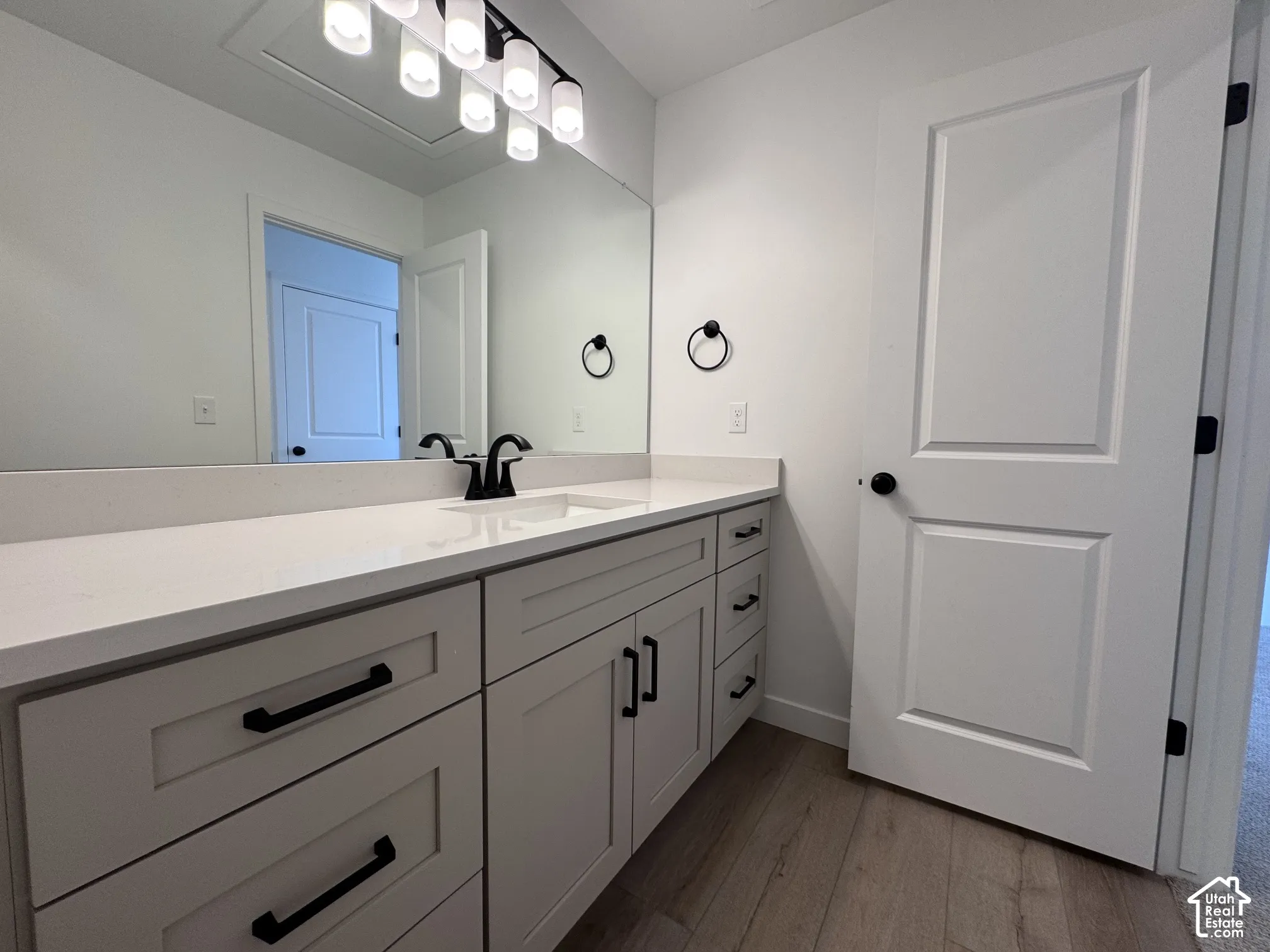 Extended vanity with an integrated sink, light-toned countertop, and matte black fixtures