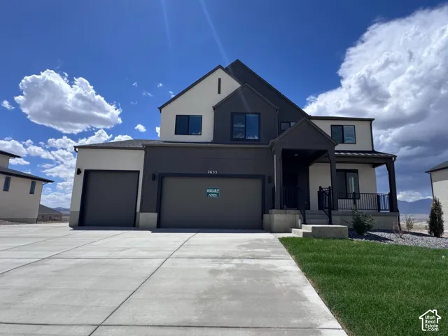 Modern two-story exterior with a covered porch, attached two-car garage, and a concrete driveway