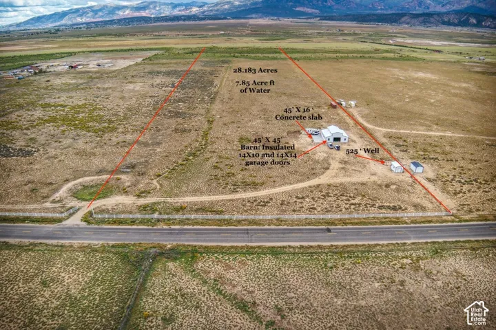 28.183 acres of land featuring a 45' x 45' insulated barn with 14'x10' and 14'x14' garage doors, a 45' x 16' concrete slab, and a 525' well