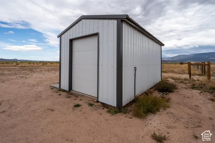 Metal utility building featuring corrugated siding and a roll-up door