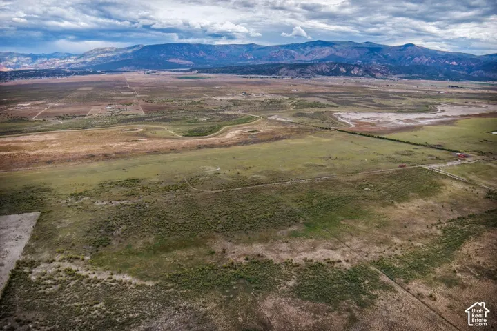 Expansive terrain with varied ground cover and distant mountains