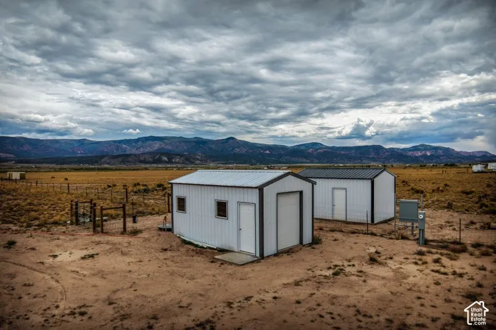 Two detached structures with metal siding and roofs, set on an expansive, arid terrain