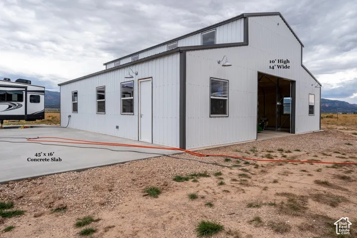 Metal-sided structure with a gabled roof and multiple windows