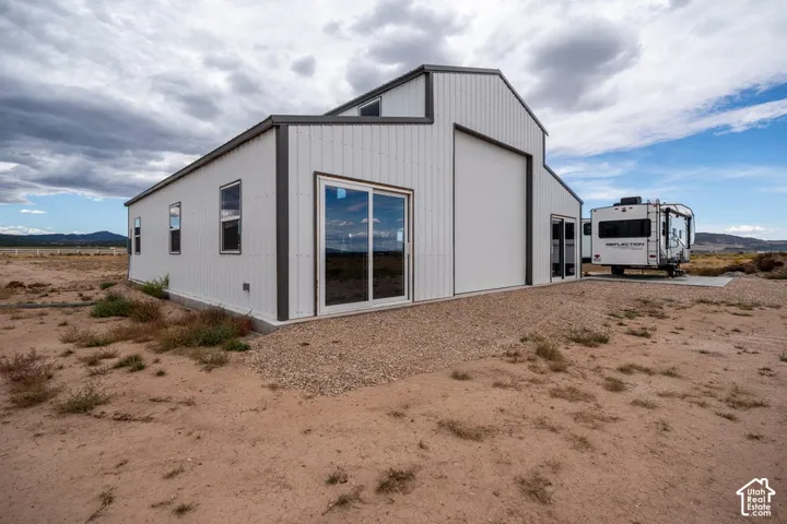 Metal-clad structure featuring a gable roofline and large sliding glass door