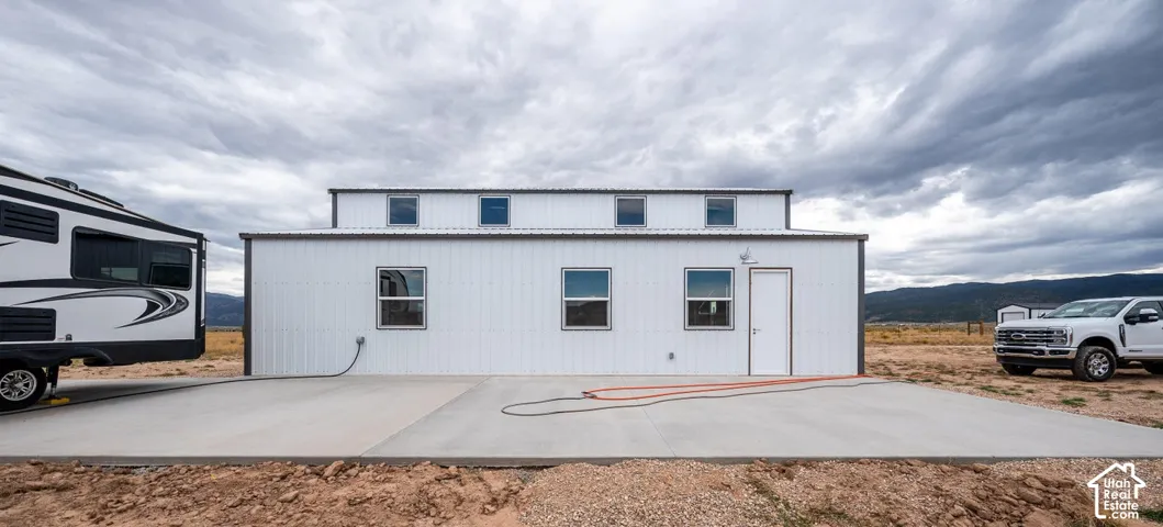 White metal-sided structure with a gray metal roof