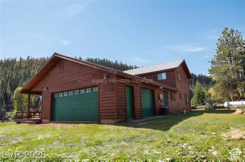 Wood-finish exterior with a metal roof, multiple garage doors, and a covered porch