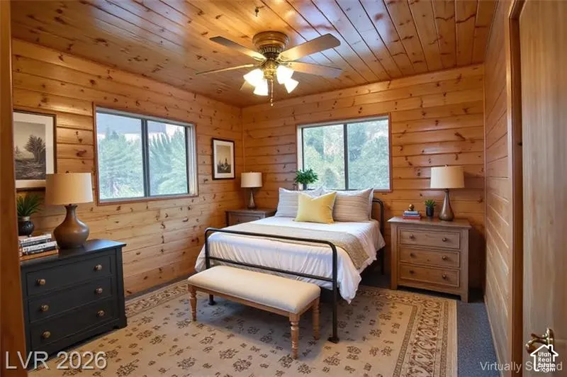 Wood-paneled walls and ceiling, dual windows, and a ceiling fan with integrated lighting