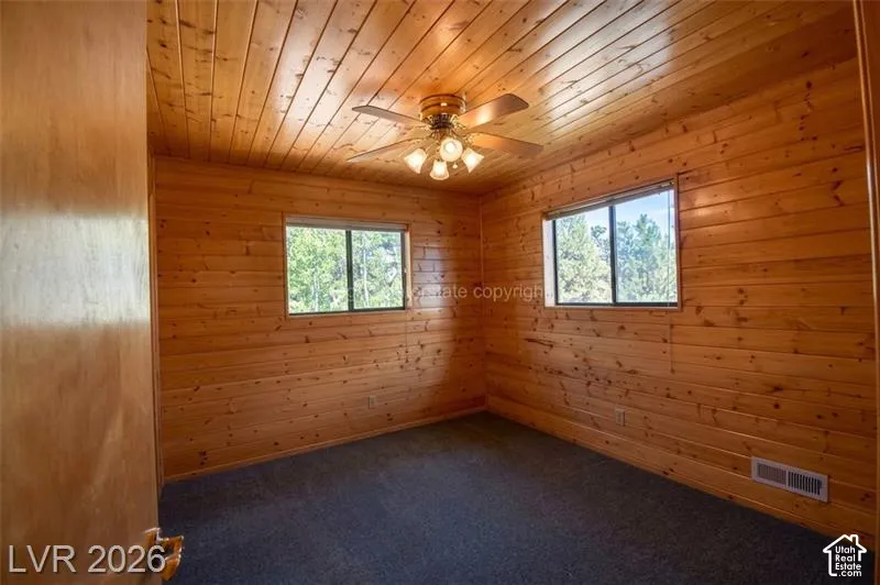 Wood-paneled walls and ceiling with a ceiling fan light fixture