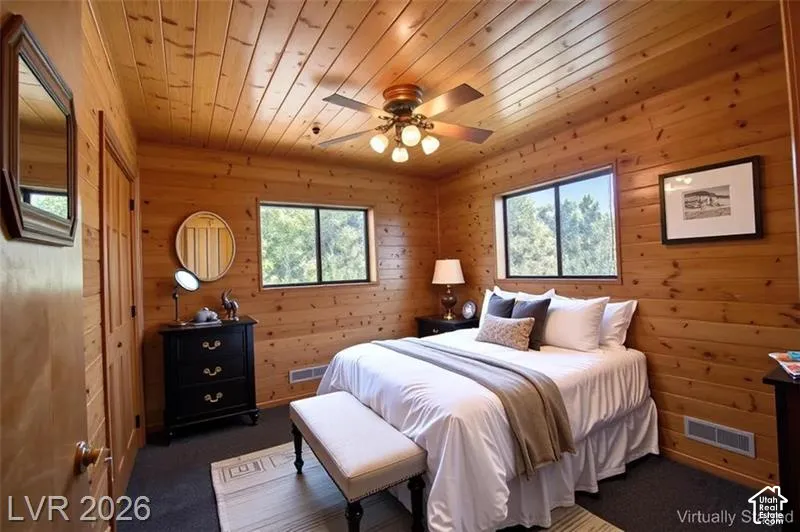 Wood-paneled walls and ceiling, dual windows, and ceiling fan with integrated lighting