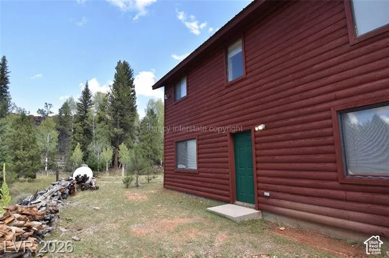 Red-stained log siding exterior with a green entry door