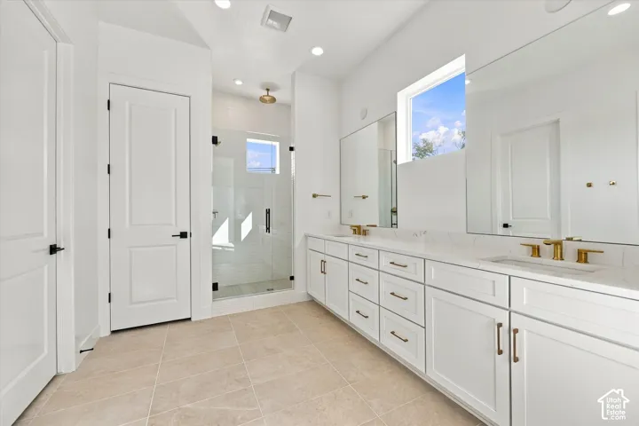 Dual vanities with white cabinetry and gold-tone hardware