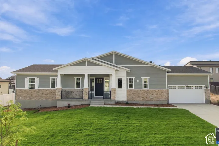 Ranch-style residence featuring a covered front porch, stone and siding exterior, attached two-car garage, and a concrete driveway