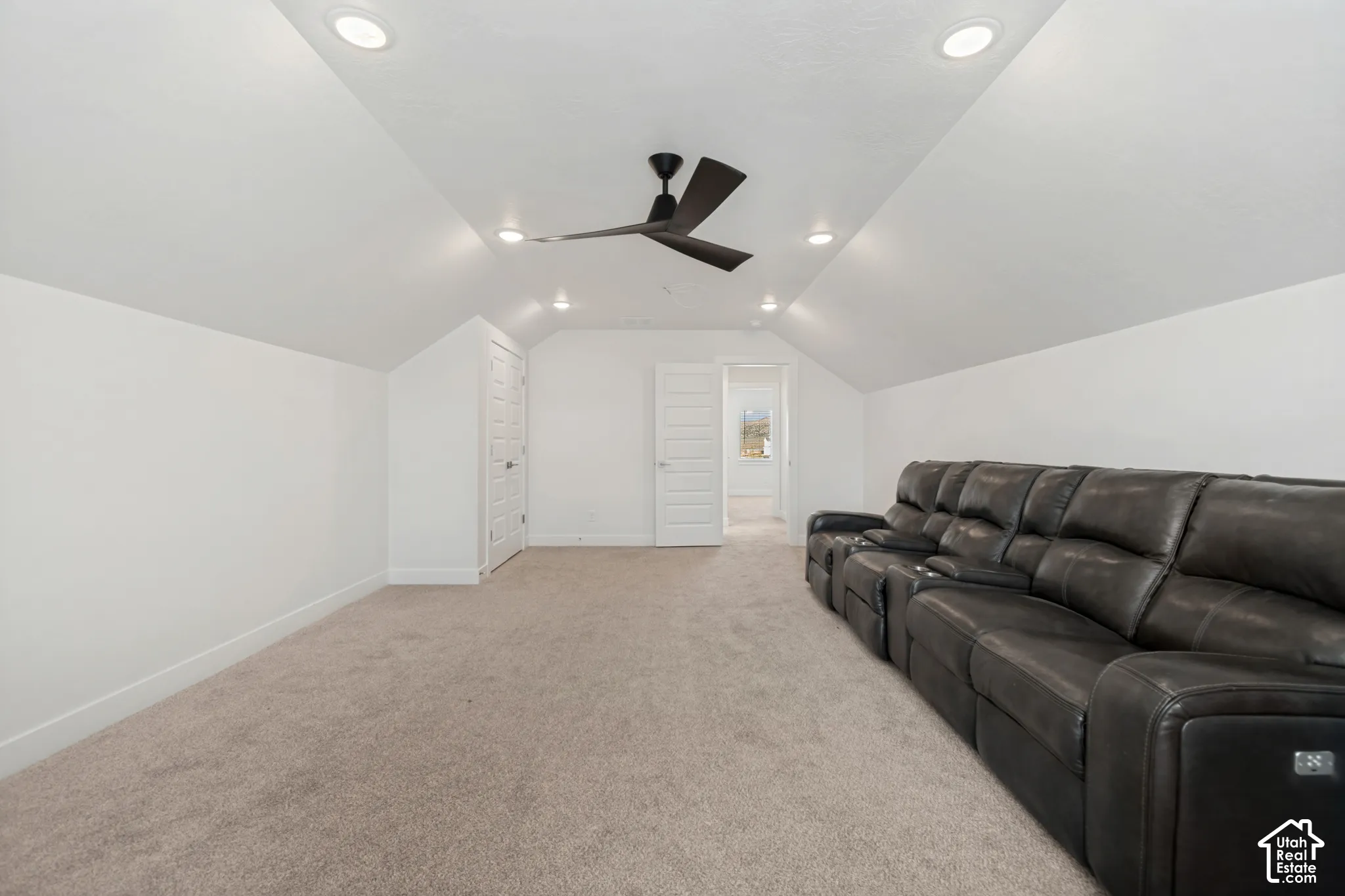 Vaulted ceiling with recessed lighting and a ceiling fan, neutral carpet flooring, and white painted walls