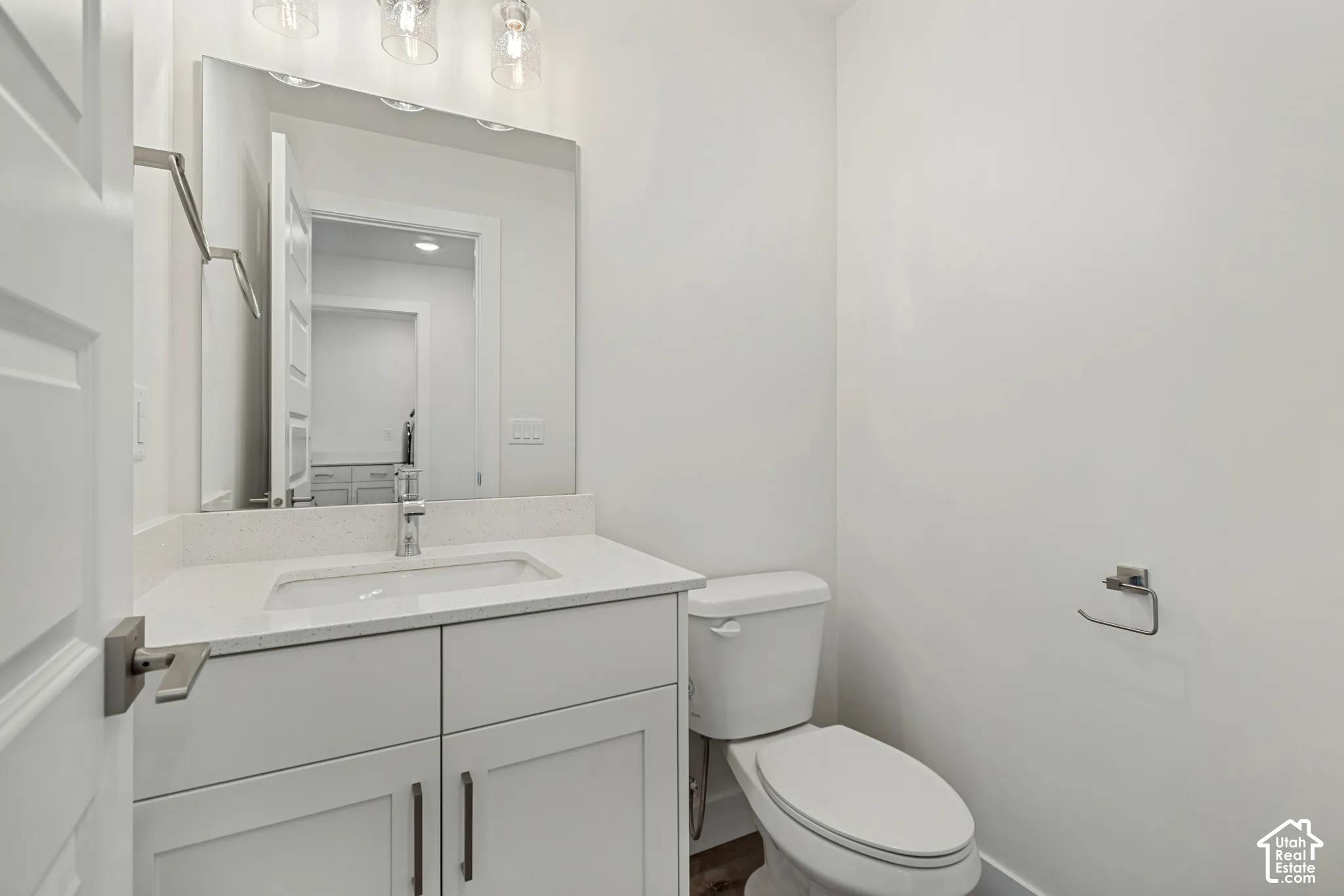 White vanity with quartz countertop, undermount sink, and chrome faucet