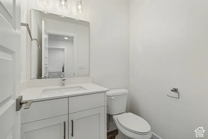White vanity with quartz countertop, undermount sink, and chrome faucet