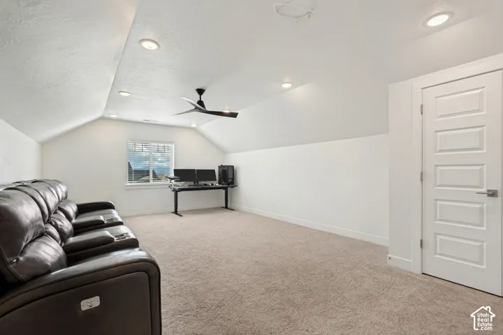 Expansive room with vaulted ceilings, recessed lighting, a modern ceiling fan, and carpet flooring
