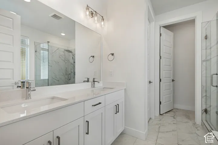 Double vanity with integrated sinks, contemporary chrome faucets, and white shaker-style cabinetry
