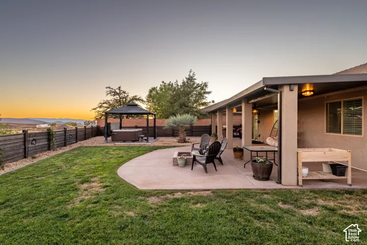 Expansive backyard featuring a manicured lawn, concrete patio, and privacy fence